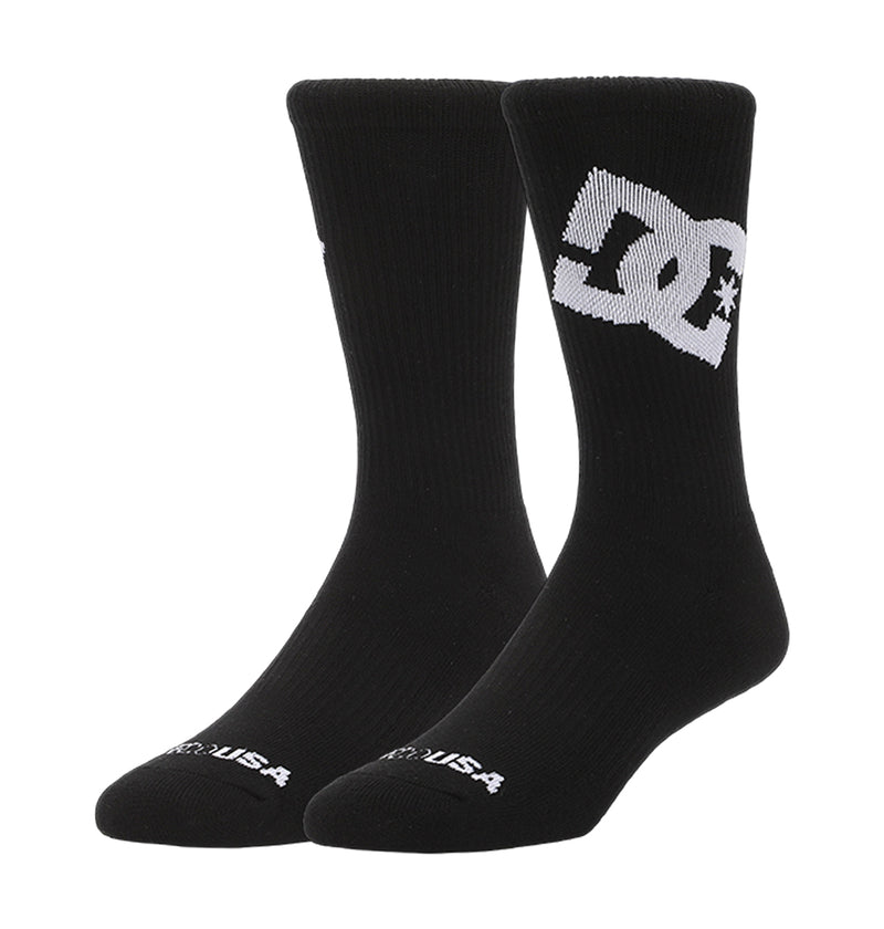 The DC Shoes Graffik Logo Crew Socks 3-Pack features black crew socks with a bold white DC Shoes logo on the side, "USA" in white on the toe, and a ribbed texture.