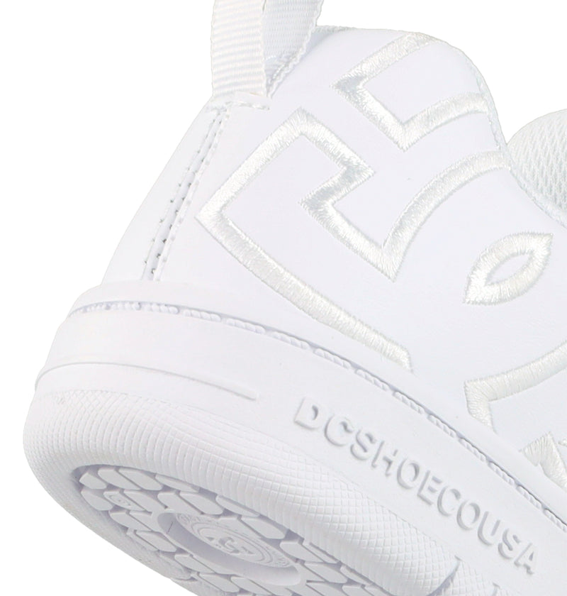 Close-up of the heel and side of DC Shoes Kids' Court Graffik Shoes, featuring raised white stitching in a stylized logo. The textured sole displays embossed DCSHOECOUSA text, highlighting their skate-inspired design for kids.