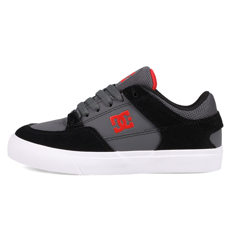 The Kids' Onyx Shoes by DC Shoes feature a black and gray vulc design, a white sole, a striking red DC logo on the side, and red accents on the tongue—perfect for everyday skate style.