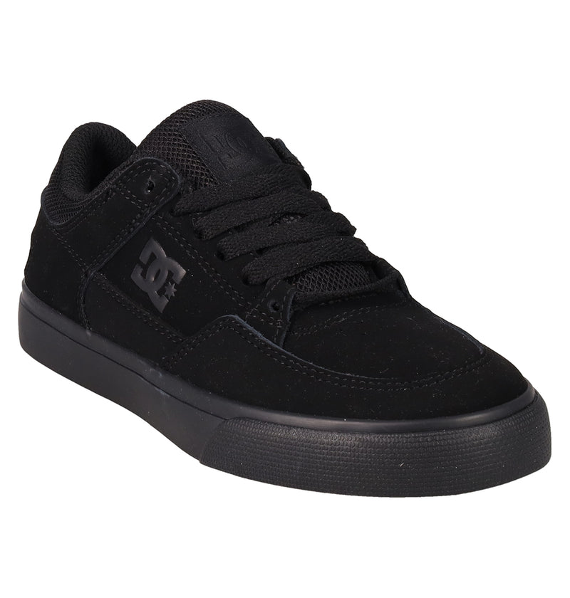 The Kids' Onyx Shoes by DC Shoes feature a black, minimal low-top design with a thick rubber sole, black laces, and DC logo on the side and tongue—shown at a slight angle against a white background.