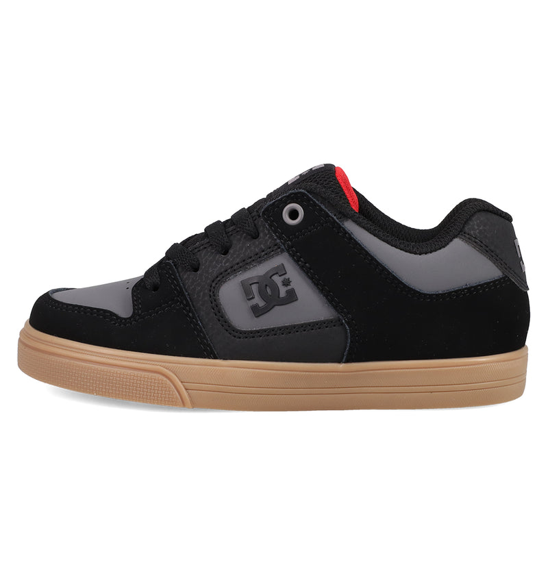 A black and gray Kids' Pure Shoe by DC Shoes with a gum sole, black laces, red tongue accent, and raised side logo—a comfortable and versatile choice for any occasion.