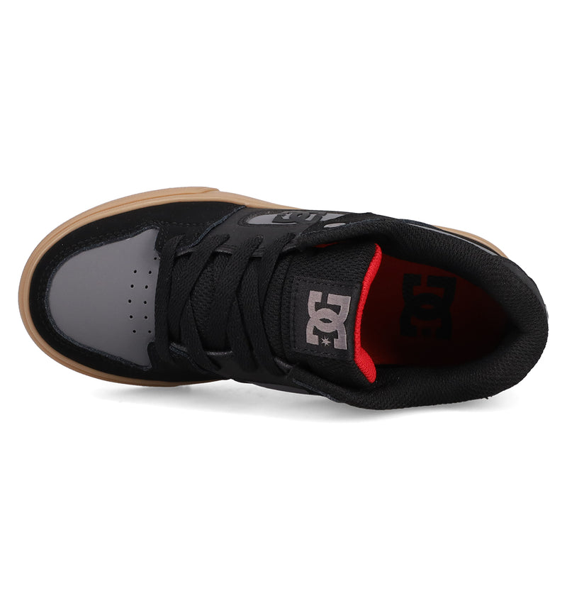 Top view of Kids' Pure Shoes by DC Shoes in black and gray with black laces, gum sole, and red heel lining. The tongue displays a white DC logo. These versatile shoes offer style and comfort for any occasion.