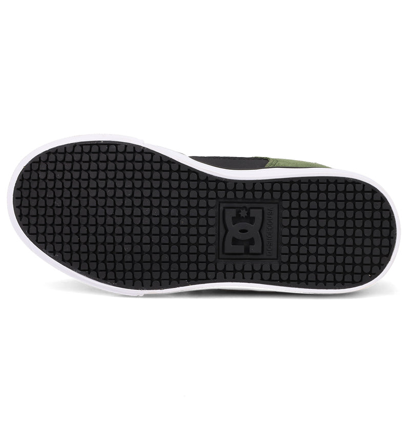 The image shows the sole of DC Shoes Kids' Pure Shoes with a textured black rubber surface and white edge. The DC Shoes logo appears in the center, highlighting this comfortable and versatile design.