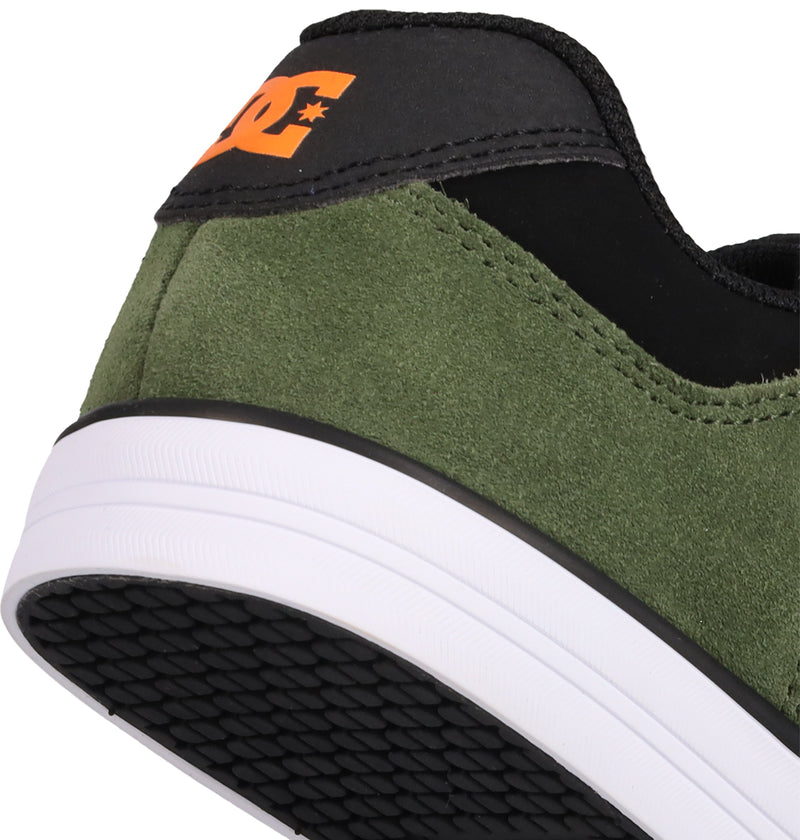 Close-up of the heel of DC Shoes' Kids' Pure Shoes in green and black with a white sole, featuring a black section with an orange DC logo and textured rubber outsole—highlighting comfort for everyday wear.