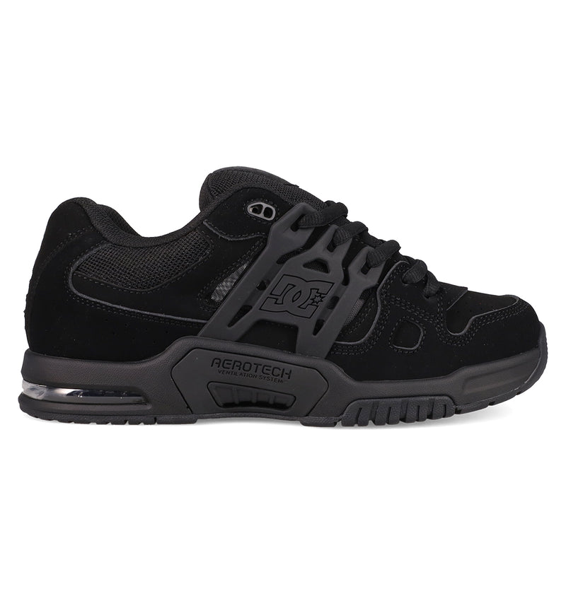 The Men's AT-2 Shoes by DC Shoes feature a black skate design with dark gray accents, mesh and suede uppers, a thick padded tongue, chunky sole, DC logo on the side, and AEROTECH branding to showcase its breathable AEROTECH ventilation system.