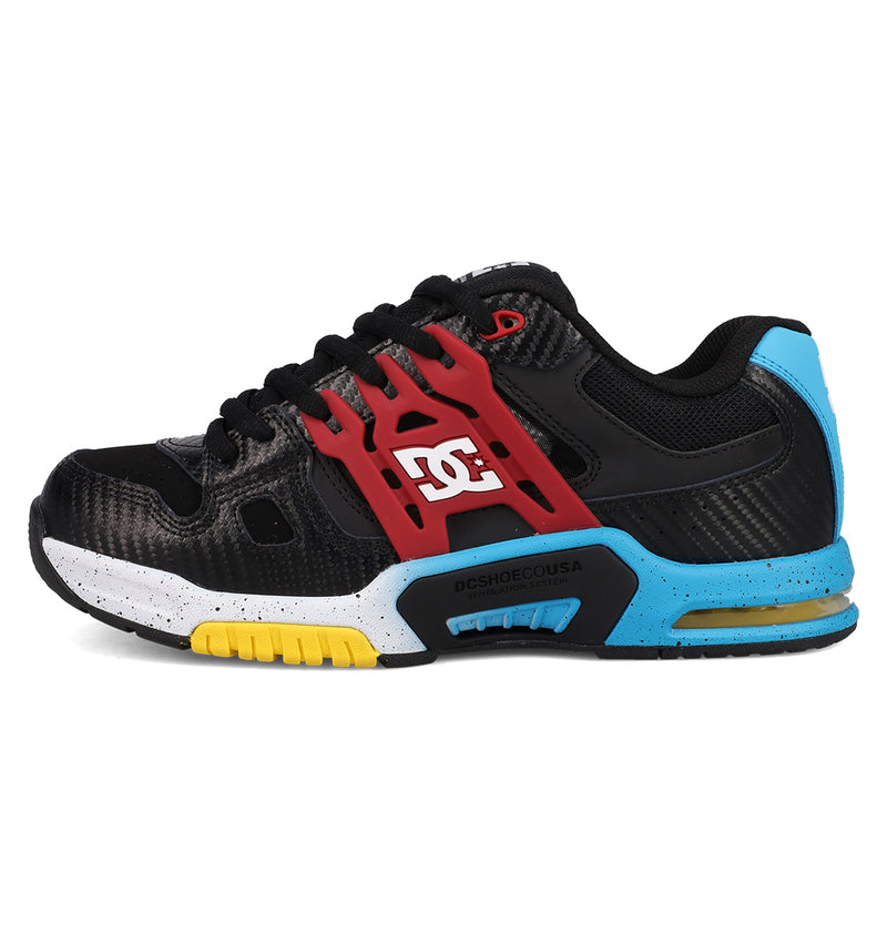 The DC Shoes Men's AT-2 features a black athletic design with a red cage, white DC Shoes logo, blue heel, yellow and blue midsole accents, speckled white detailing above the sole, and superior cushioning for all-day comfort.