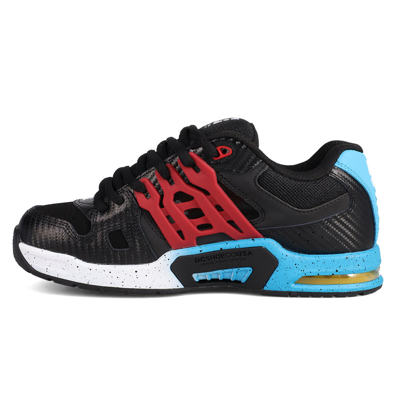 The Men's AT-2 Shoes by DC Shoes are black athletic sneakers with red cage details, a white speckled midsole, blue and yellow heel accents, black laces, and advanced AEROTECH ventilation for breathable comfort.