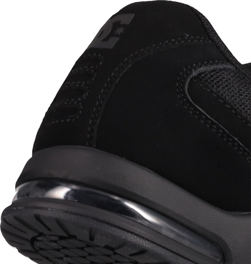 Close-up of the heel and sole of the black Men's AT-2 Shoes by DC Shoes, highlighting the textured airband outsole tread, visible air cushion in the sole, detailed stitching, and part of the logo on the upper.
