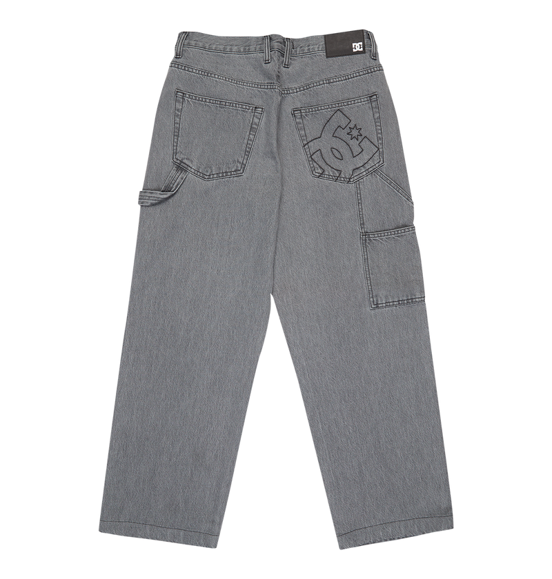 The Men's Baggy Denim Carpenter Pant by DC Shoes features heavyweight denim, a wide-leg fit, multiple pockets, a hammer loop, and a large DC Shoes logo embroidered on the right pocket.