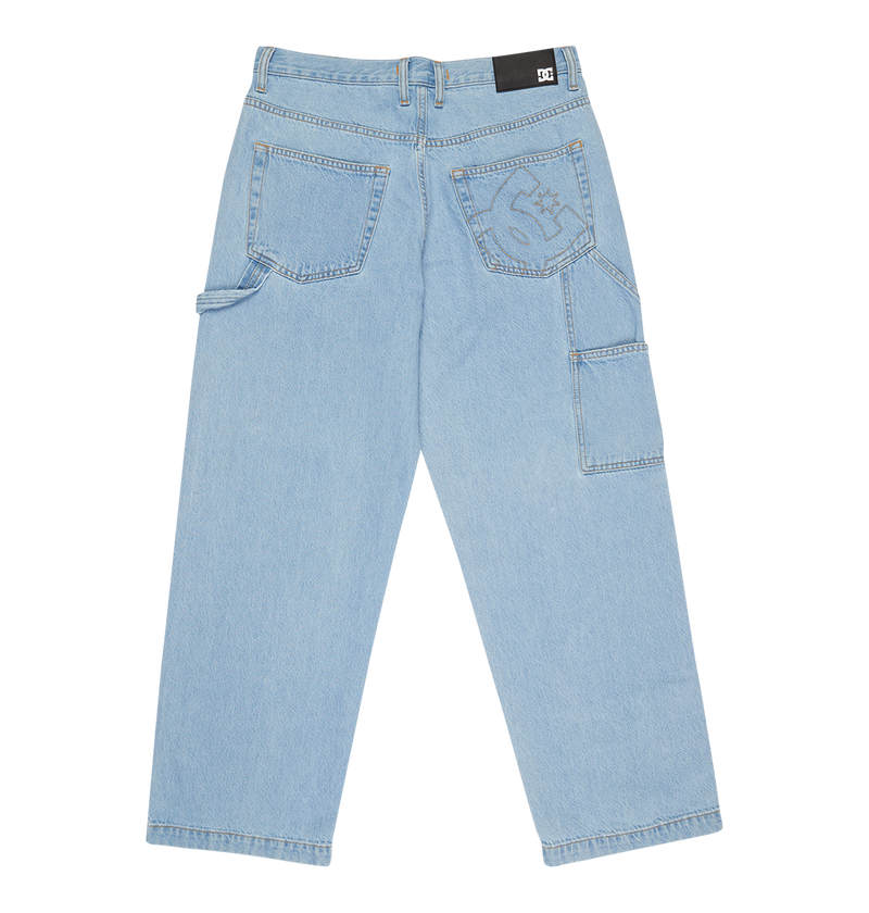 Men's Baggy Denim Carpenter Pant by DC Shoes shown flat from the back, with two large back pockets, a black brand patch on the waistband, side utility pockets, and visible stitching details on heavyweight light blue denim.