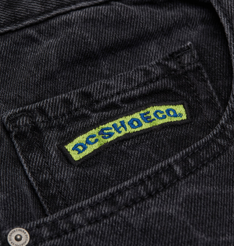 A close-up of a black denim jacket pocket with a stitched DC Shoes patch in green and blue, paired with the Men's Baggy Denim Snake Print Pant for an authentic streetwear vibe.
