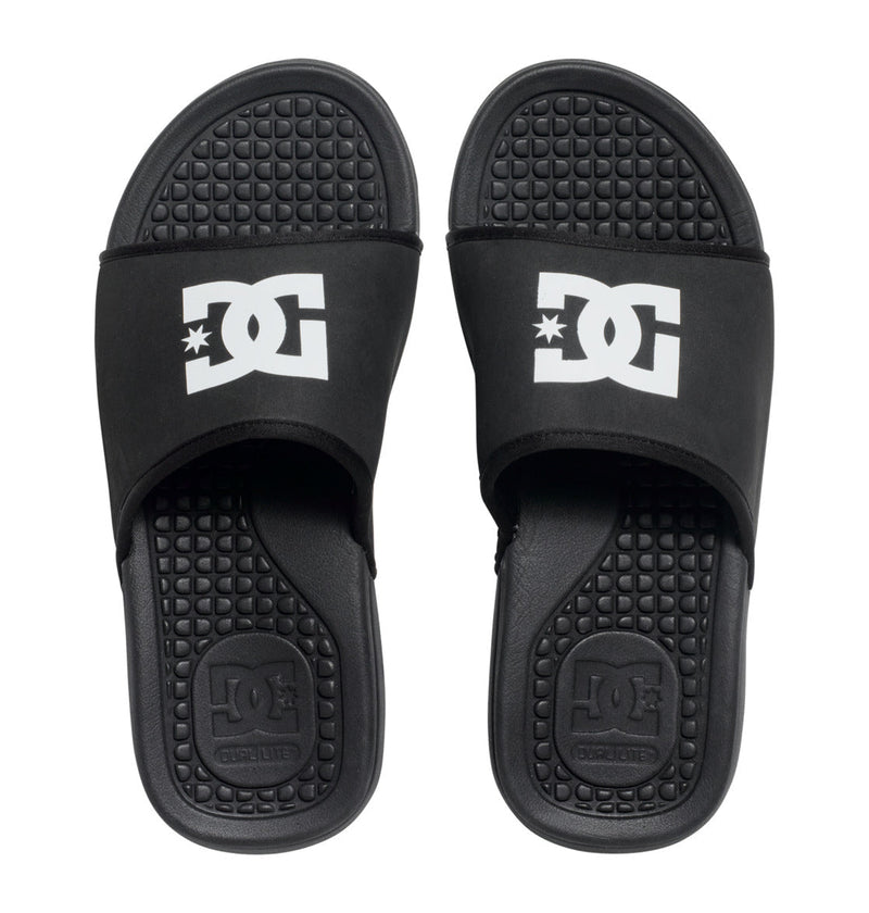 The DC Shoes Men's Bolsa Slides feature black textured footbeds, wide straps with the white DC Shoes logo, and an embossed brand name on the heel. Ideal for post-skate comfort.