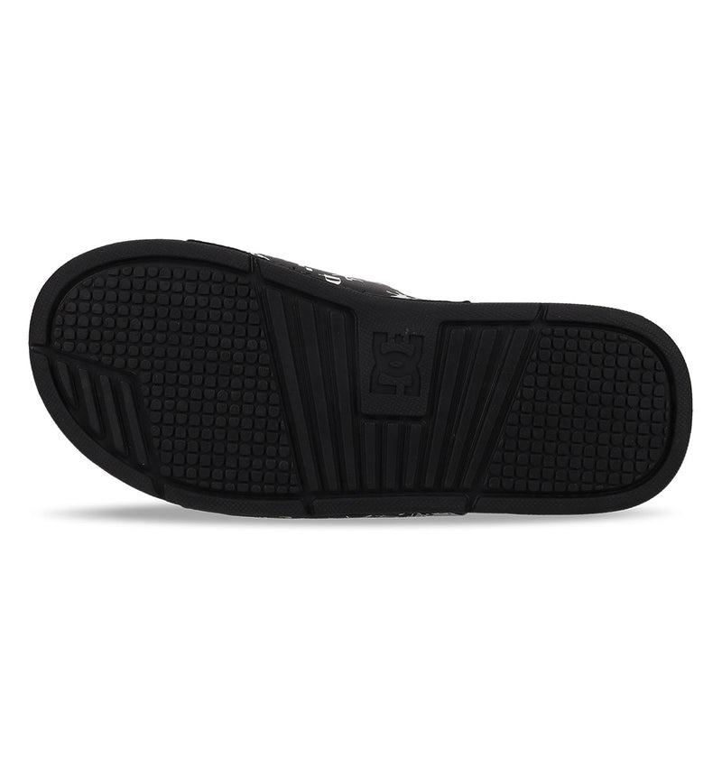 The Men's Bolsa Slides by DC Shoes feature a black sole with a textured, non-slip tread and a raised DC Shoes logo at the center, shown sole-up against a white background; ideal for post-skate comfort.