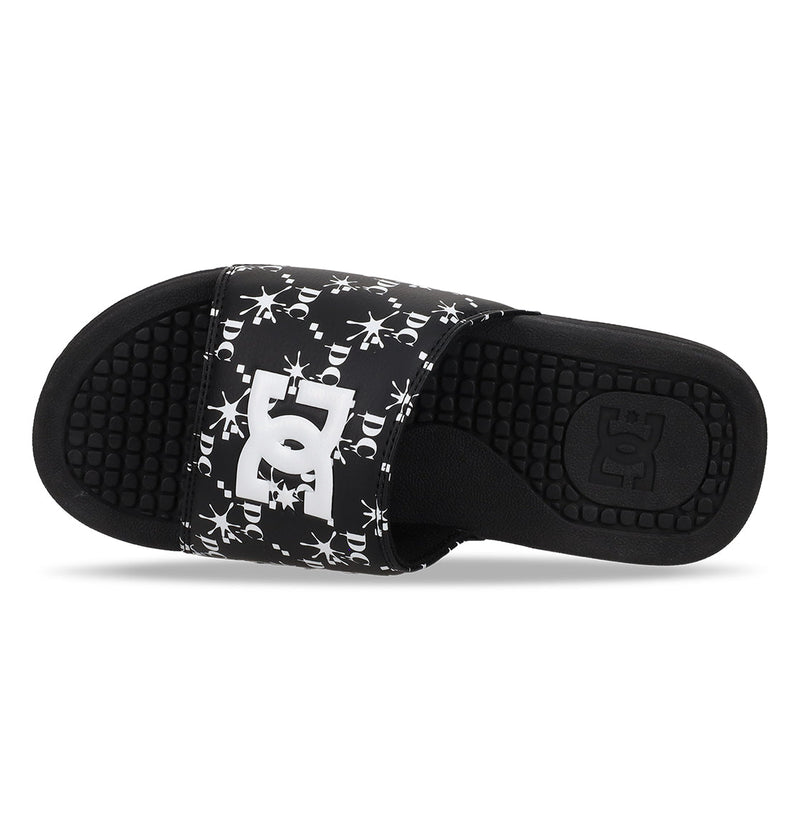 The Men's Bolsa Slides from DC Shoes feature a black design with a textured footbed and a white DC logo on the strap, highlighted by an eye-catching white splatter pattern—ideal for your next skate session.