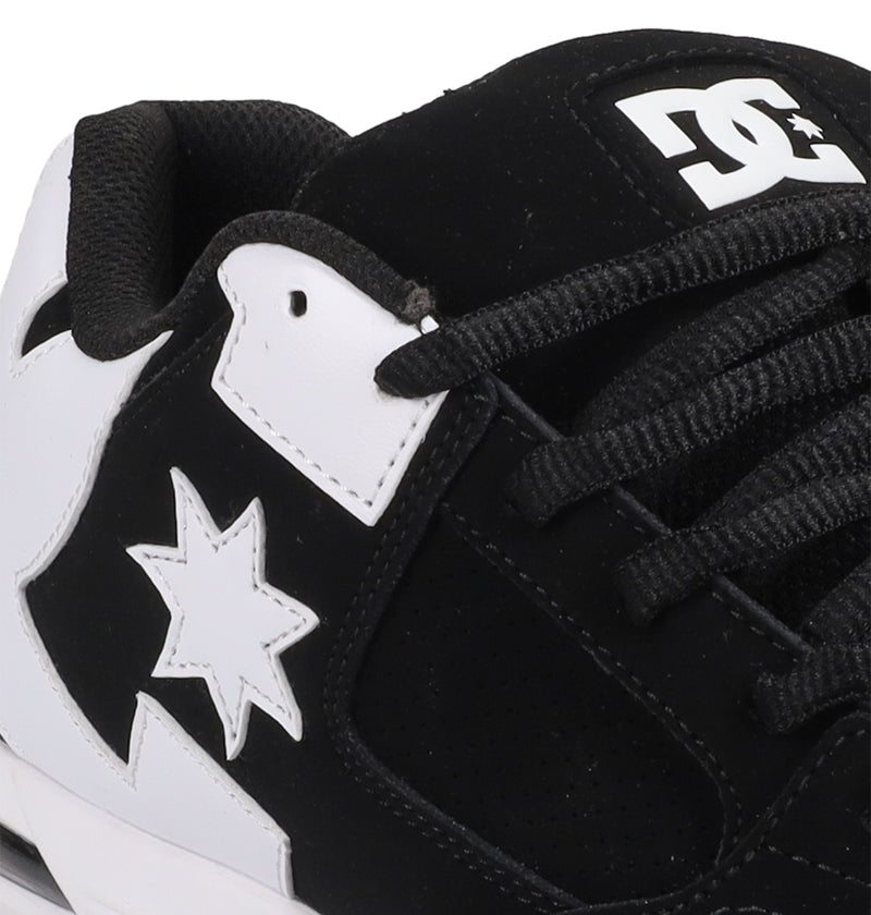 Close-up of the Men's Command Shoes by DC Shoes in black and white, showcasing the iconic logo on the tongue, black laces, and a star motif—combining classic DC style with modern sneaker features.