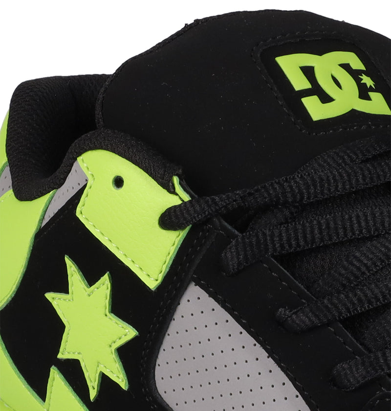 Close-up of Men's DC Command Shoes by DC Shoes in black and neon yellow, showcasing skate-inspired logo on the tongue, neon star accents, and black/gray perforated panels for a bold streetwear look.