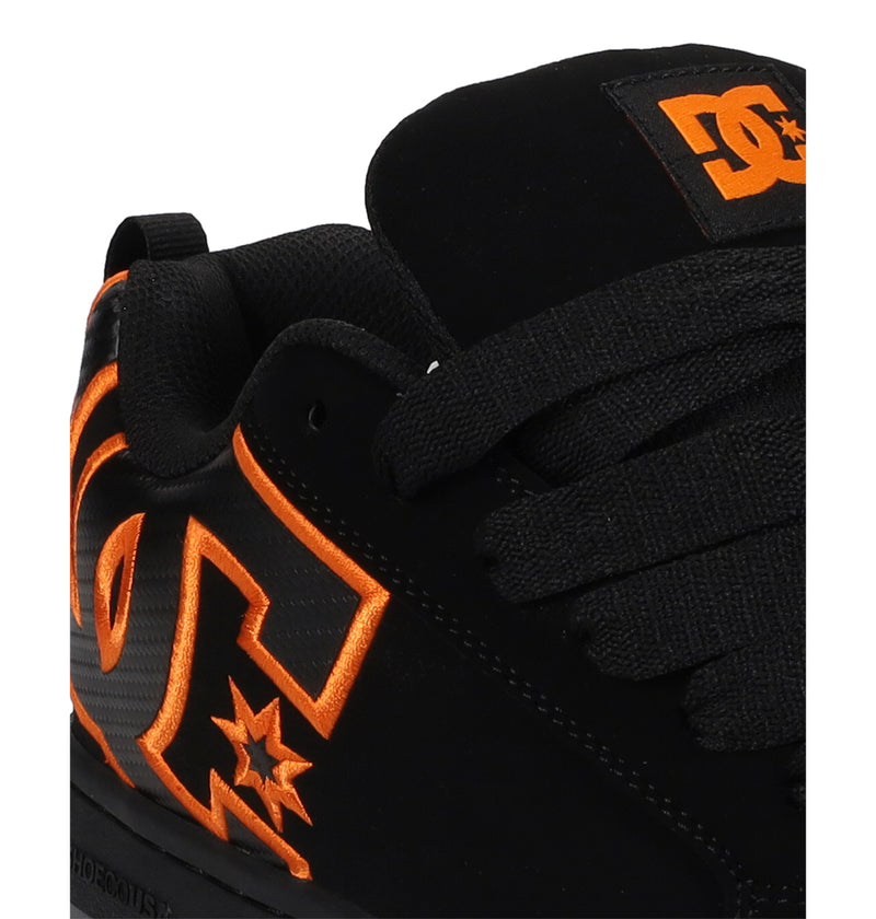 Close-up of DC Shoes Men’s Court Graffik Shoes—a black sneaker with a puffy silhouette, thick black laces, bold outlines, star detail, and orange DC logos on the side and tongue—showcasing its signature style.