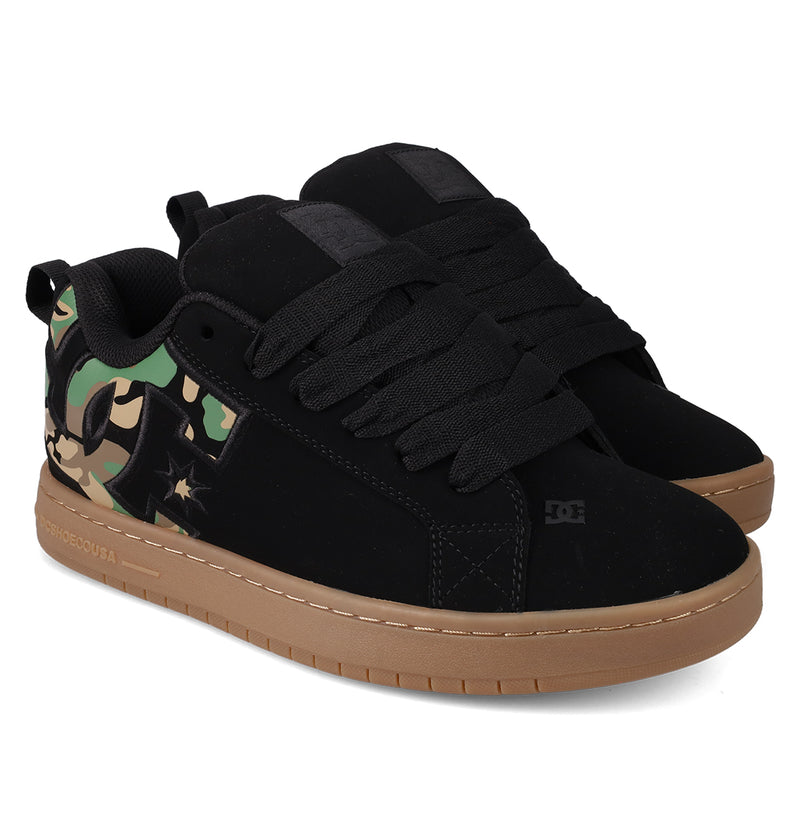 The DC Shoes Men's Court Graffik Shoes feature a puffy black silhouette, thick black laces, gum brown soles, and camouflage green accents with the DC logo on the side and a padded collar for comfort.