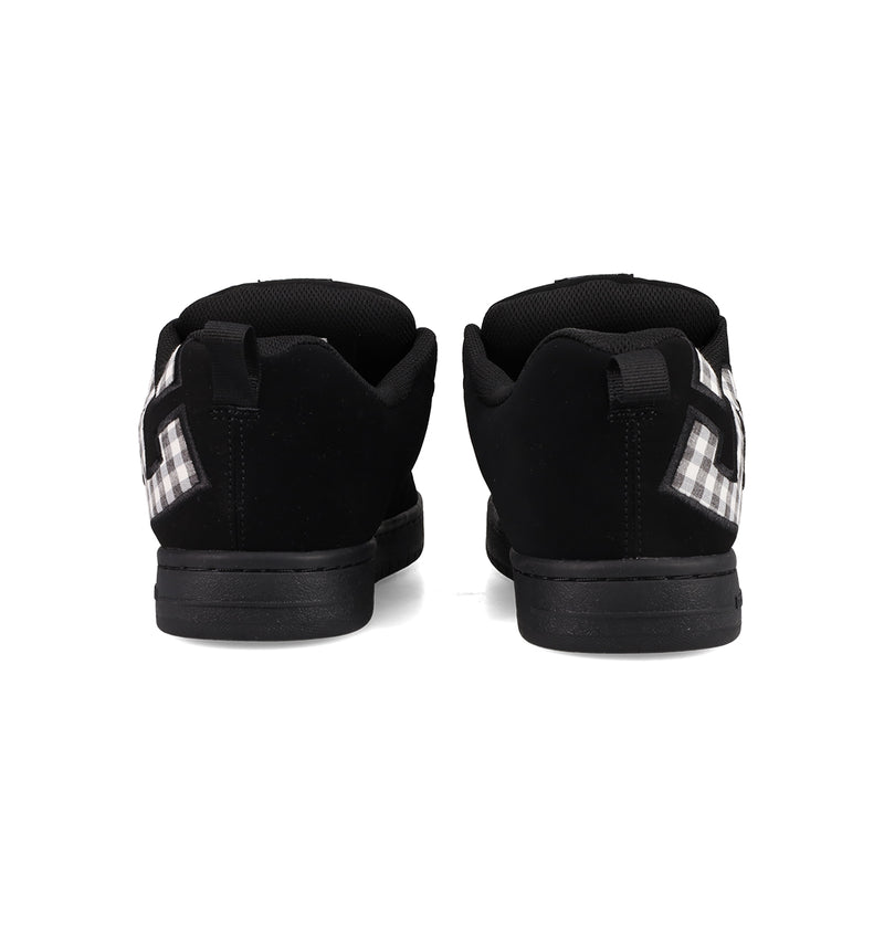 A pair of Men's Court Graffik Shoes by DC Shoes, featuring a classic puffy silhouette and black-and-white checkered side details, shown from the back on a white background.