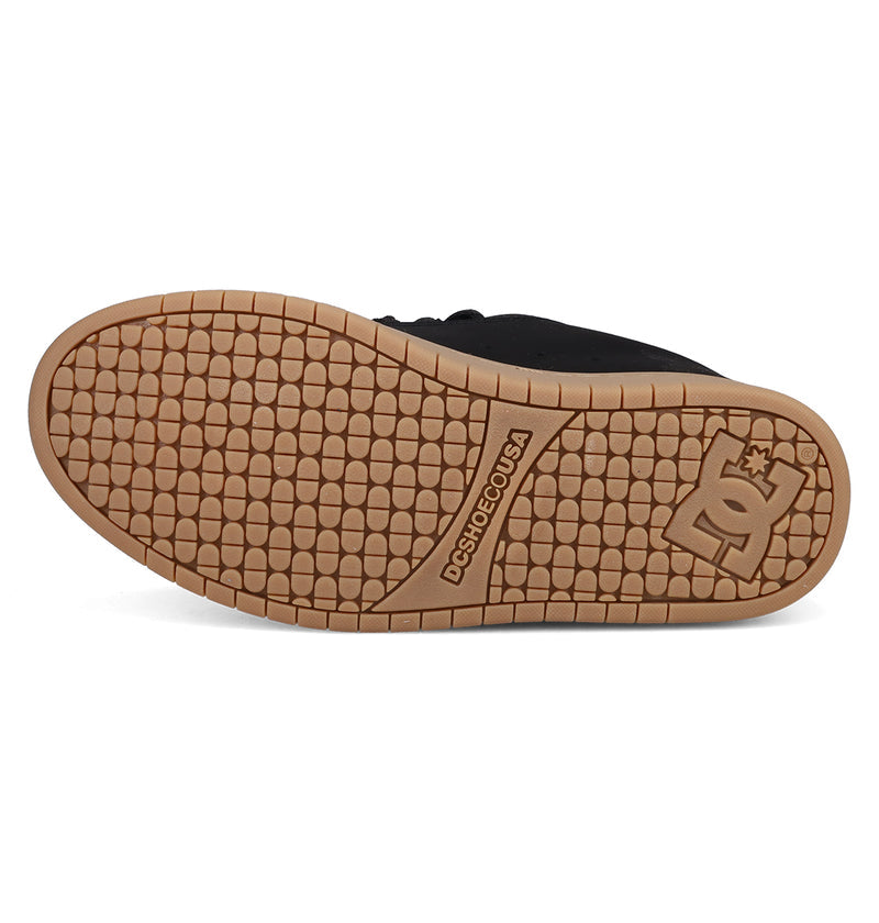 The image displays the gum-colored sole of a black Men's Court Graffik Shoe by DC Shoes, with a honeycomb tread, DC logo and star near the heel, and "DCSHOECOUSA" visible on the midsole.