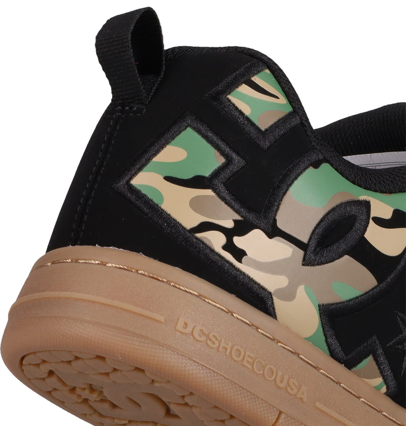 Close-up of the Men's Court Graffik Shoe heel by DC Shoes, showing the DC logo on black, tan, and green camo with bold black detailing, tan rubber sole, and "DGSHOECOUSA" embossed in the signature puffy silhouette.