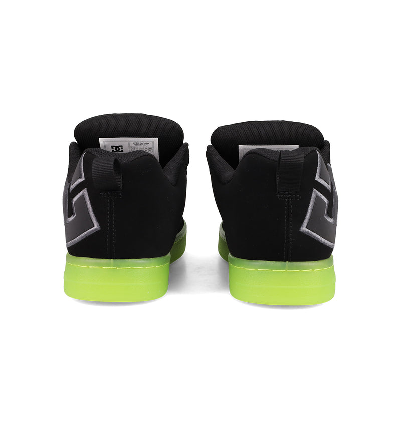 The DC Shoes Men's Court Graffik SE Shoes feature a puffy silhouette, black uppers, bright green soles, and a white and gray geometric heel design. Seen from the back, they include on-trend colorways and black pull tabs at the heel.