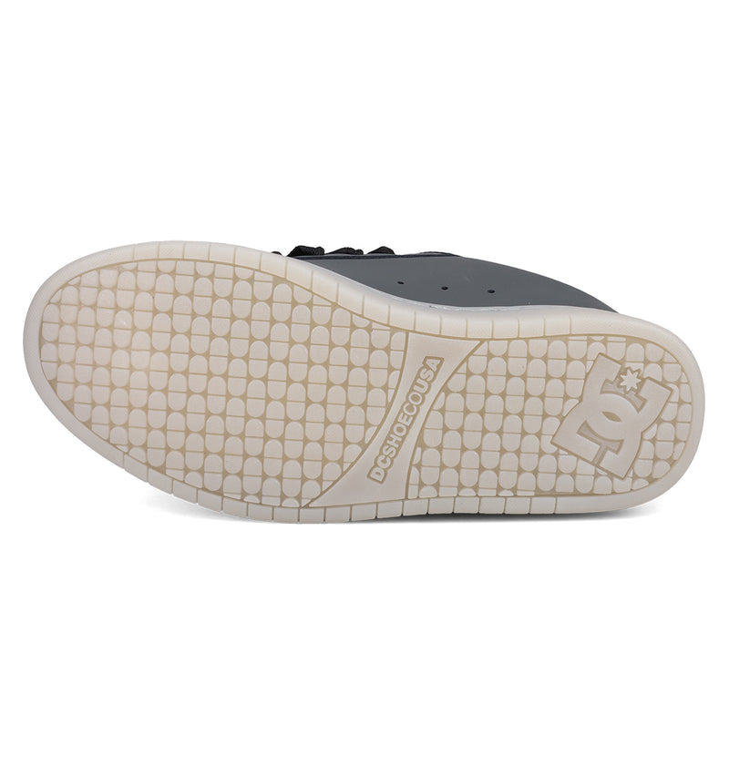 The image shows the white sole of DC Shoes Men's Court Graffik SE Shoes from below, featuring a tread of small raised rectangles and DCSHOECOUSA branding with the DC Shoes logo near the heel—matching its puffy silhouette.