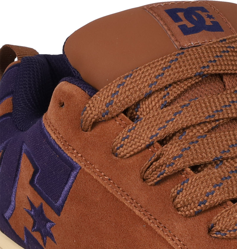 Close-up of DC Shoes Men's Court Graffik SE sneaker in brown suede with a puffy silhouette, purple DC logo detailing on side and tongue, matching purple lining, and coordinated brown and purple laces for a stylish look.