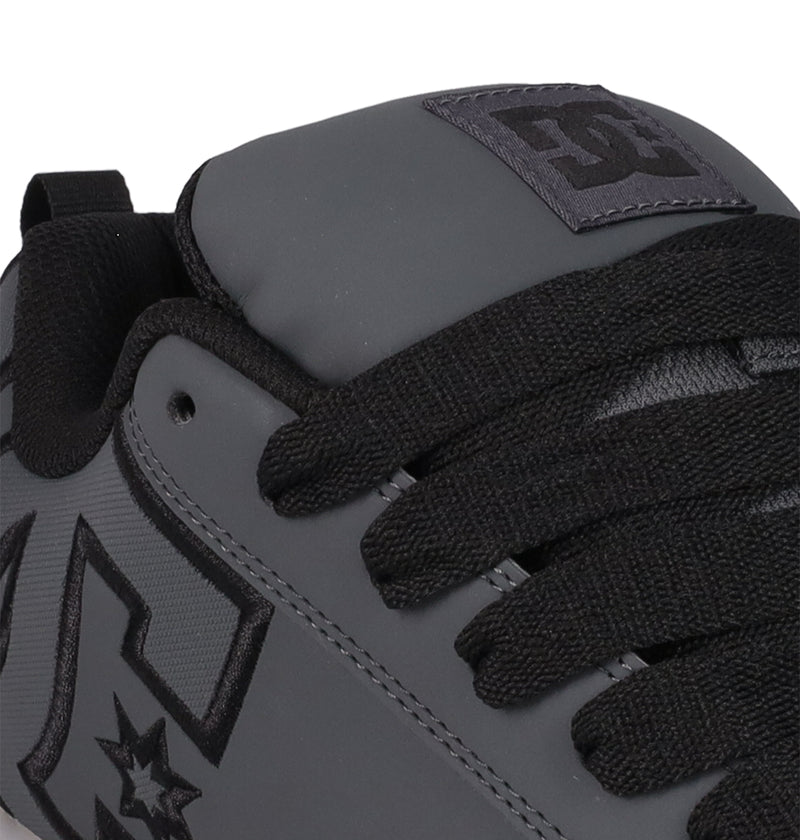 Close-up of the DC Shoes Men's Court Graffik SE sneaker in gray with black laces, a visible logo on the side and tongue, premium uppers, black trim, and a puffy silhouette for an on-trend style.