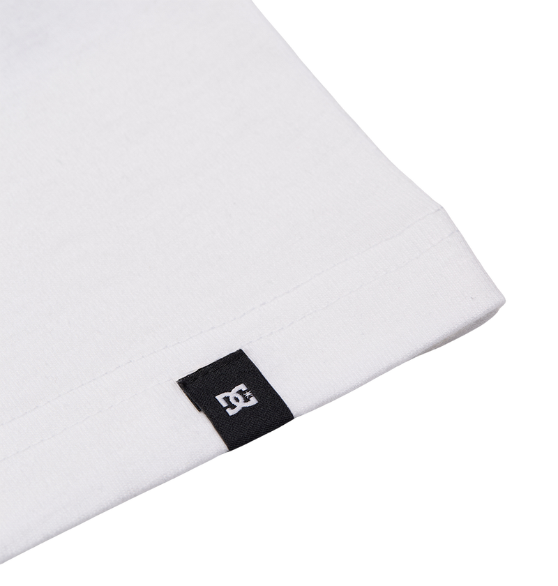 Close-up of the hem on the Men's DC Corpo Tee by DC Shoes, showing a small black fabric tag with the white DC Shoes logo stitched to the edge.
