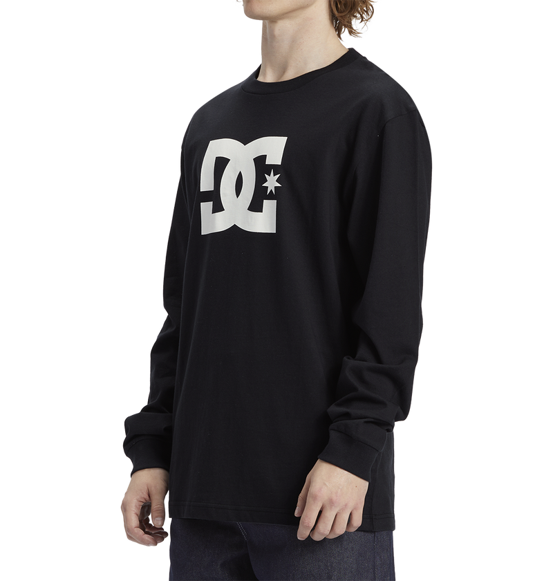 A man models the Men's DC Star Tee by DC Shoes—a black long-sleeve shirt with the white DC Shoes logo on the chest—against a plain white background.
