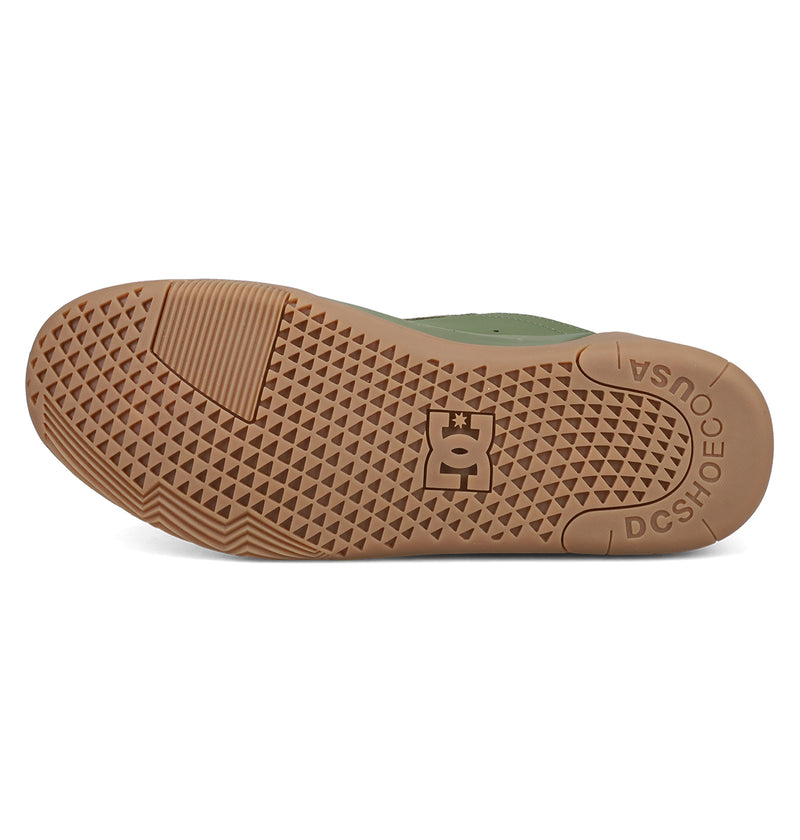 The image displays the brown rubber sole of DC Shoes Men's Fractal Shoes, featuring a textured triangular grip and the DC Shoes logo at the center. "DC SHOE CO USA" is embossed near the heel, reflecting skate-inspired style.