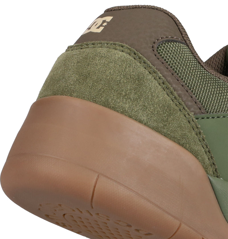 Close-up of the heel on DC Shoes' Men's Fractal Shoes, featuring green and brown suede and leather, a textured gum sole, and a white DC logo on the heel tab for street style and comfort.