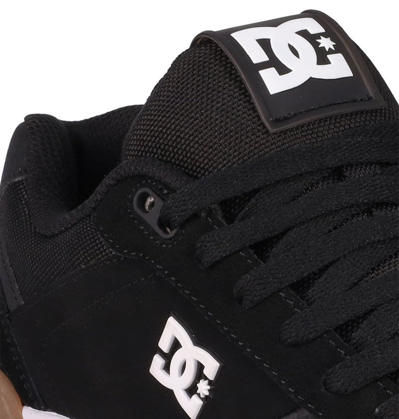 Close-up of the Men's Fractal S Shoes by DC Shoes in black, featuring black laces and white DC logos on the tongue and side. Crafted from a mix of suede and mesh, these sneakers deliver street-ready style.