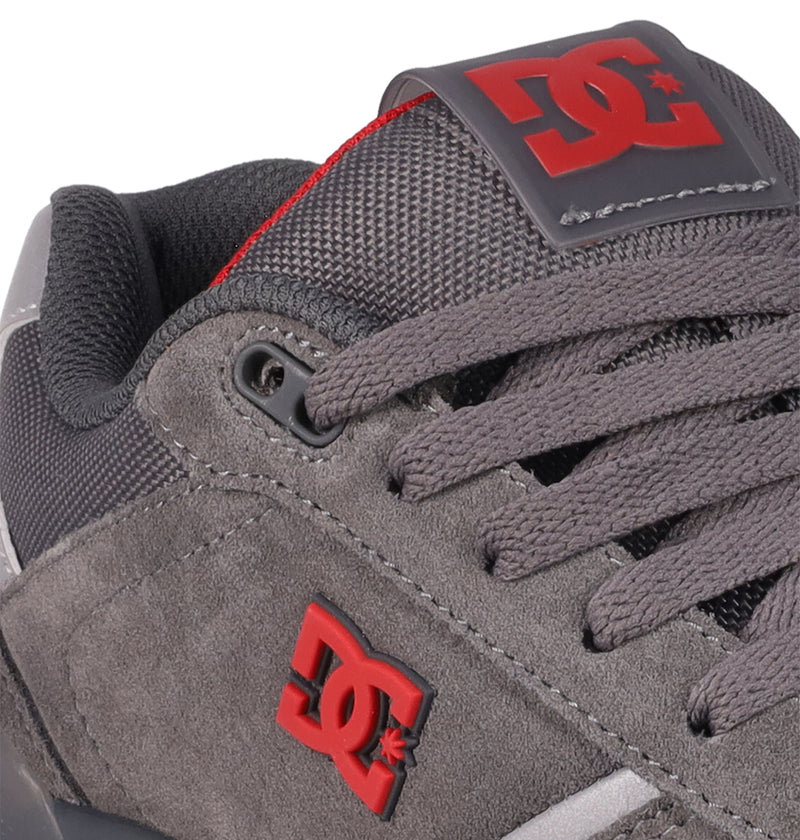 Close-up of Men's Fractal SE Shoes by DC Shoes in gray suede and mesh, featuring matching laces and a red DC Shoes logo on the side and tongue—performance-driven sneakers built for street-ready comfort.