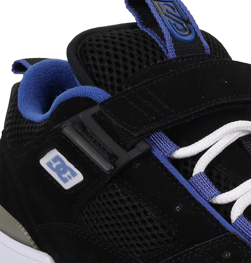 Close-up of DC Shoes Men's JS-1 Shanahan Pro Skate Shoe in black and blue, featuring white laces, a mesh upper, velcro strap, and the DC Shoes logo on the side.
