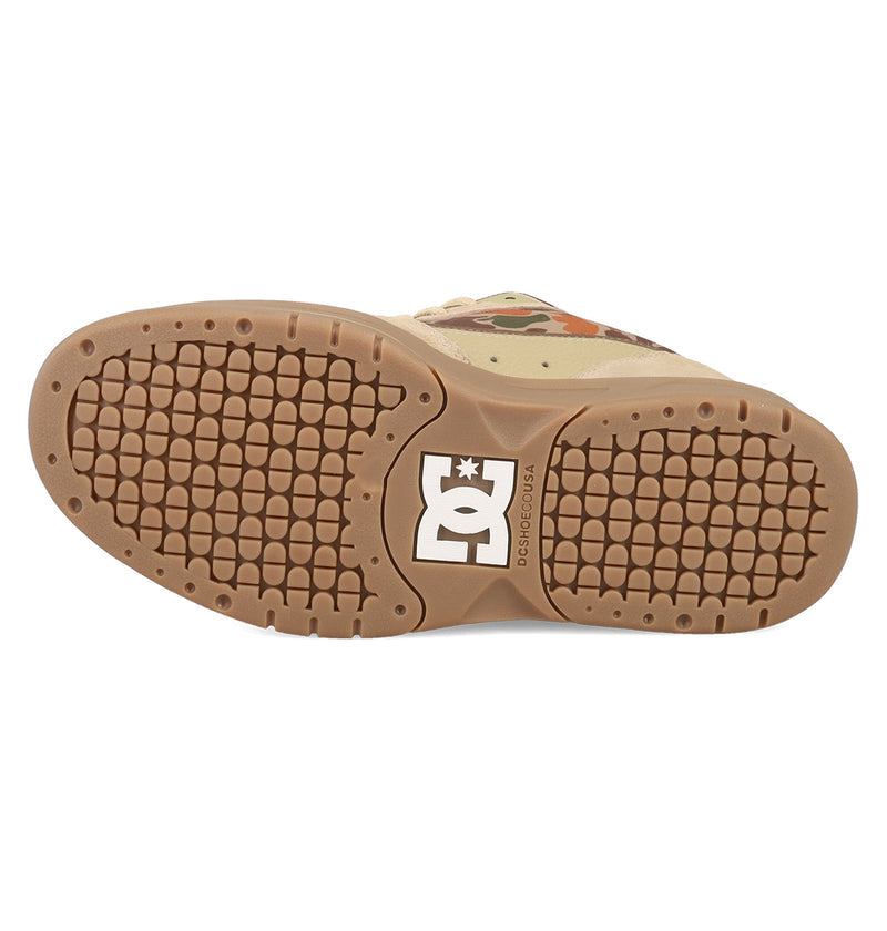 The image shows the sole of the Men's JS 2 Shoes by DC Shoes in light brown, with a textured tread and a white DC logo near the heel, highlighting DC heritage and John Shanahan’s signature style.