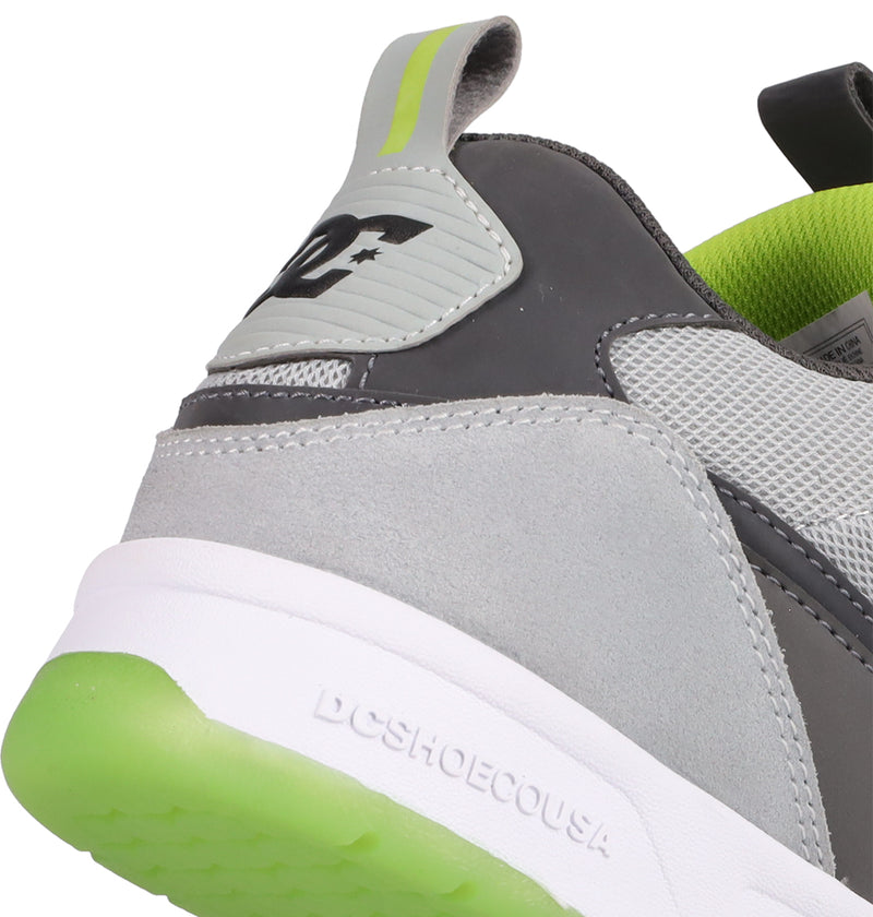 Close-up of the heel of DC Shoes Men's JS 2 Shoes in gray and white with green accents, featuring a raised DC logo on the heel tab and "DCSHOECOUSA" printed on the white sole.