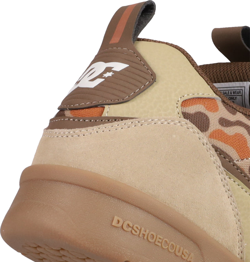 Close-up of the heel of DC Shoes Men's JS 2, featuring beige, brown, and tan camo suede and leather, DCSHOECOUSA embossed on the sole to honor John Shanahan’s DC heritage. The DC Shoes logo is displayed on the heel tab.