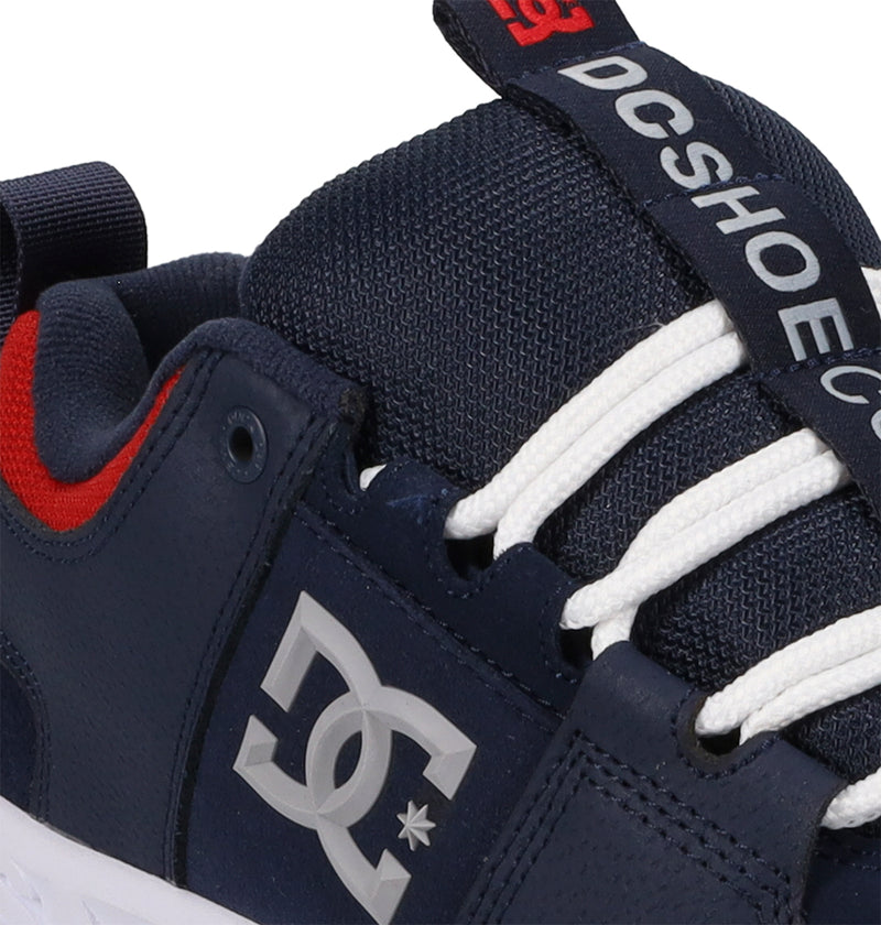 Navy blue DC shoes with white laces on a white background