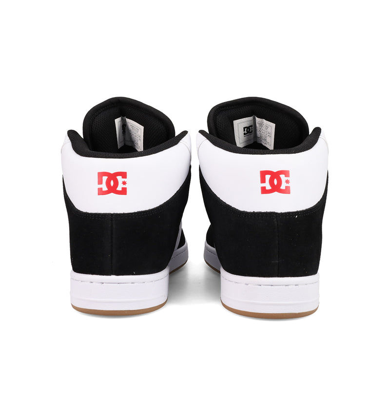 A pair of Men's Manteca 4 Hi Shoes by DC Shoes in black and white, seen from the back with a red DC logo on each heel and vintage high-top basketball-inspired details.