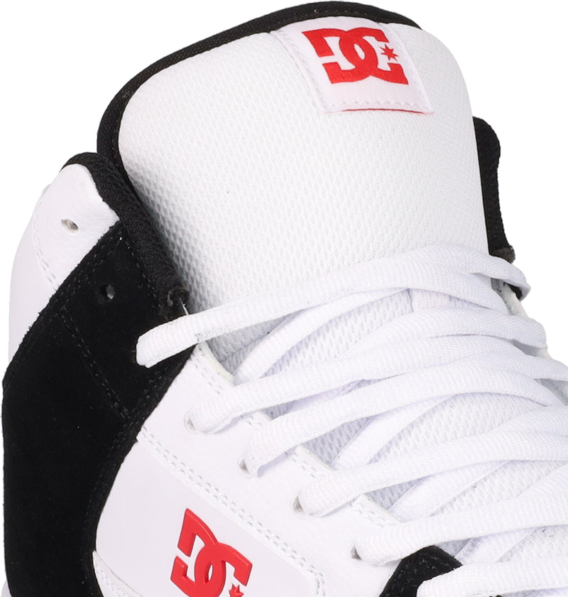 Close-up of DC Shoes Men's Manteca 4 Hi, a white and black high-top basketball sneaker with white laces and red DC Shoes logos on the tongue and side. This classic vintage style is by DC Shoes.