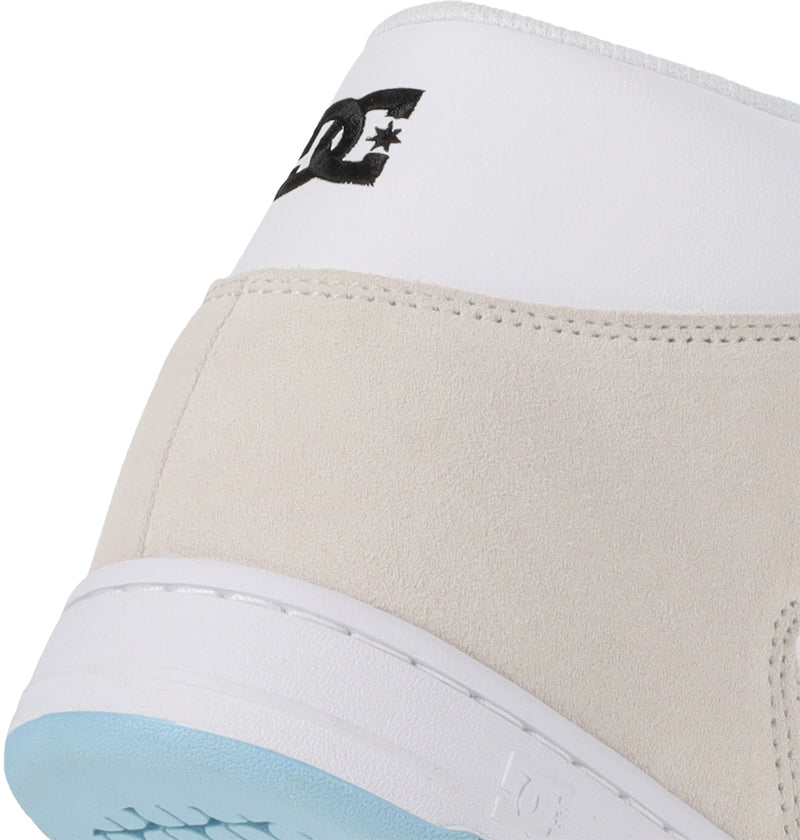Close-up of the Manteca 4 Hi heel by DC Shoes, featuring white leather at the top with a black DC Shoes logo, beige suede below, and a light blue sole.