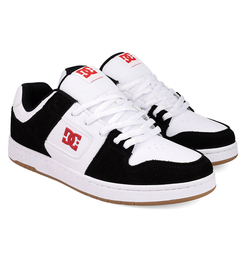 A pair of Men's Manteca 4 DC Shoes featuring white laces, a white mesh upper, black suede overlays, classic red DC logos on the side and tongue, and a gum rubber sole.