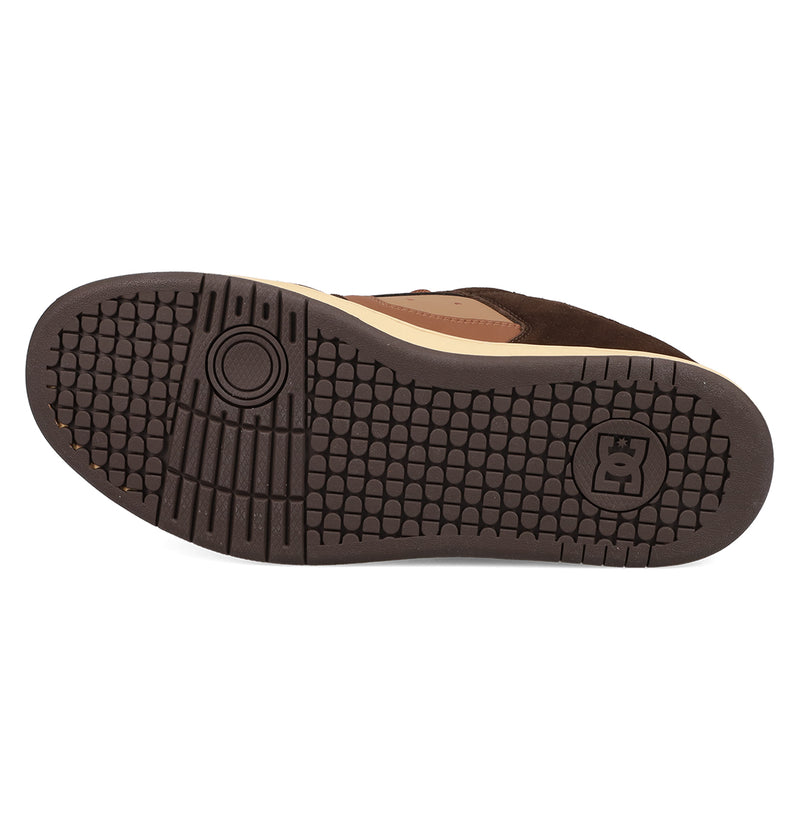 The image shows the dark brown rubber sole of a classic skate shoe with a textured grid and circular grip. The DC Shoes logo is near the heel, and the upper edge is tan and brown, characteristic of DC Shoes' Men's Manteca 4 Shoes.