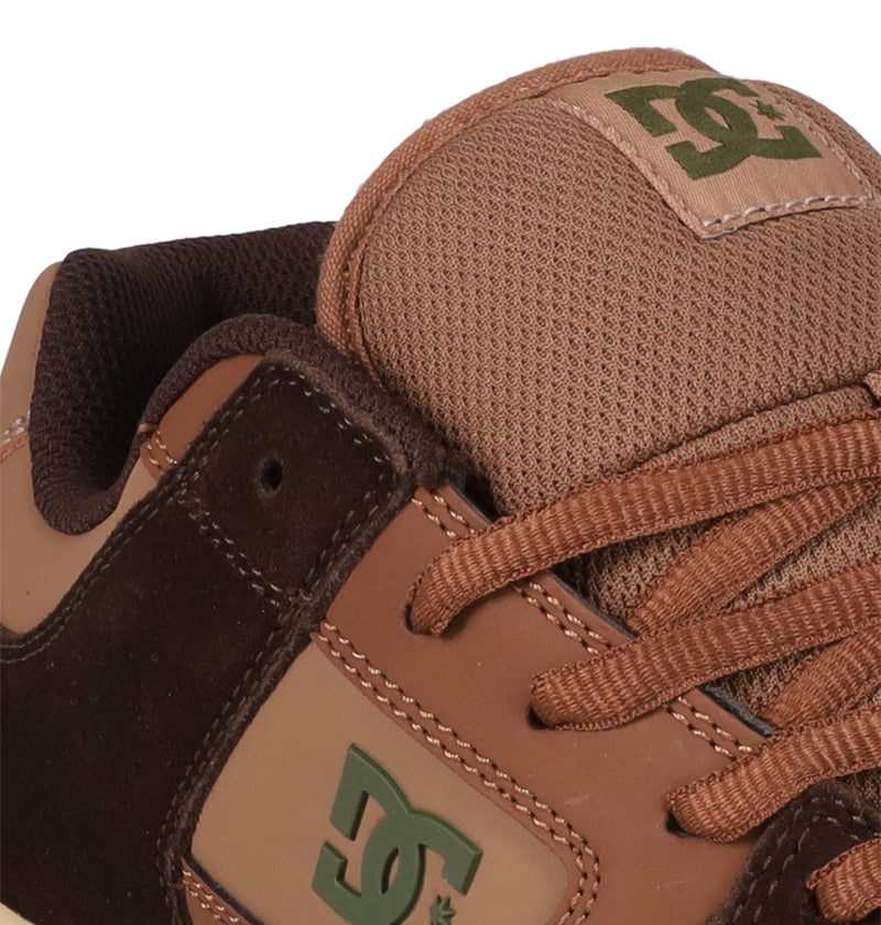 Close-up of DC Shoes Men's Manteca 4: features a brown suede and leather upper, brown laces, classic skate style, and the DC logo prominently displayed on the tongue and side.