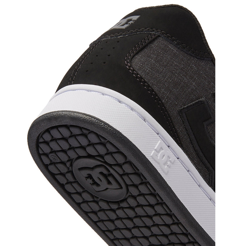 Close-up of the heel and outsole of DC Shoes Men's Net Shoes in black with a white midsole. This puffy sneaker features durable materials for comfort and longevity, with the DC logo on the side and outsole tread.