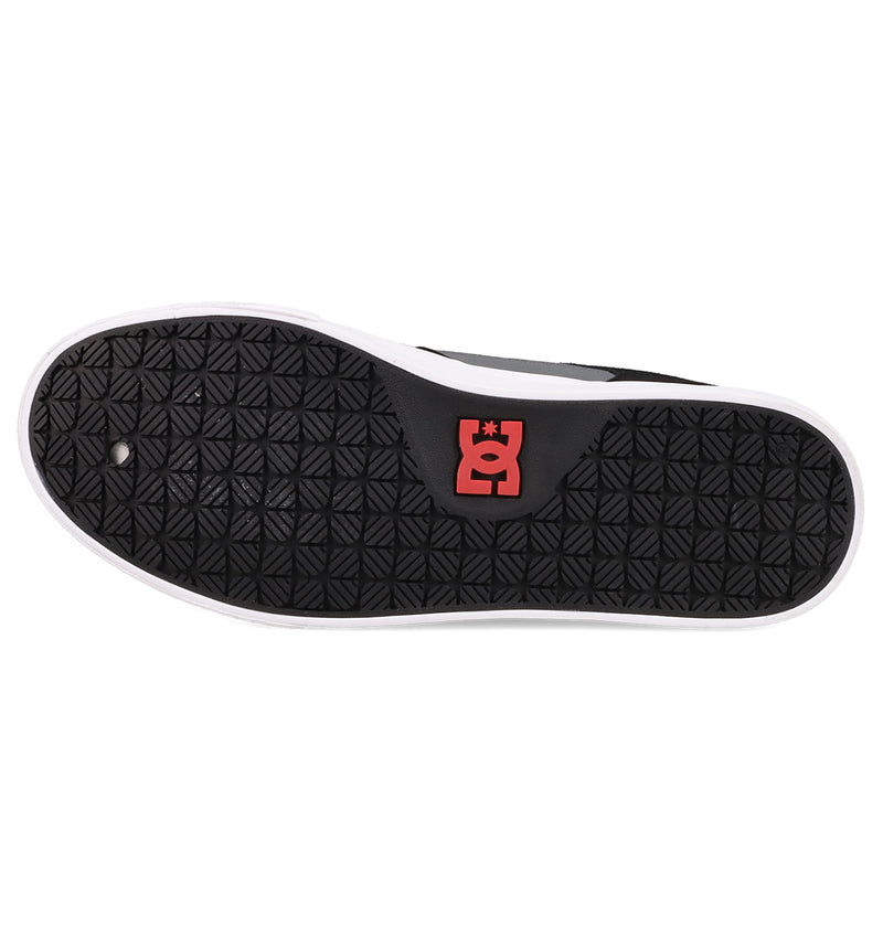 The image displays the black rubber sole of the Men's Onyx Shoes by DC Shoes, featuring a minimal silhouette with a white outer edge, a red and white DC Shoes logo by the heel, and a repeating diamond tread pattern.