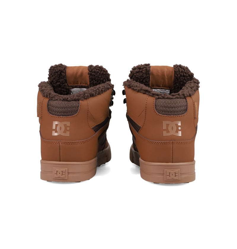 A pair of Men's Pure High Top WC Shoes by DC Shoes, featuring a brown upper, dark brown fleece lining, and vulcanized outsole, shown from the back against a white background.