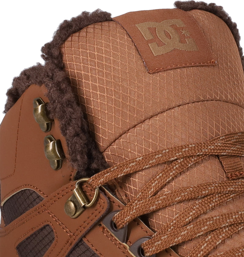 Close-up of the Men's Pure High Top WC Shoes by DC Shoes, featuring brown textured fabric, metal eyelets, patterned laces, faux fur ankle lining, a visible DC logo on the tongue, and a durable vulcanized outsole.